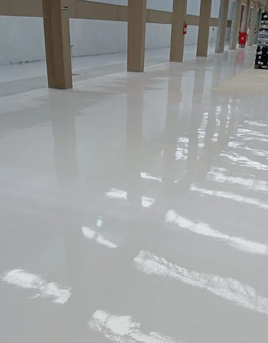 Piso industrial com pintura epóxi clara e acabamento brilhante em área interna